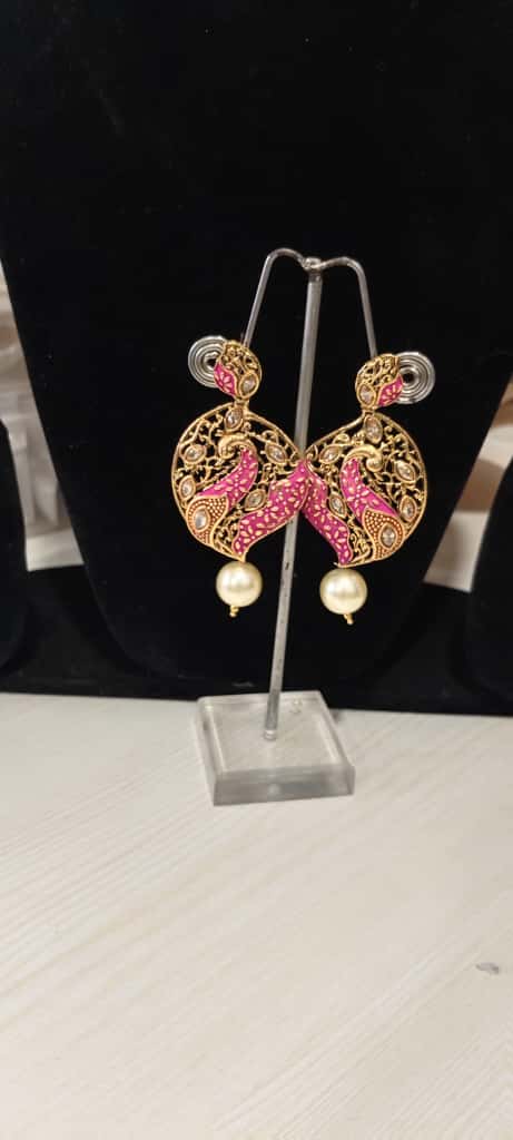 The earrings are gold-plated, meenakari earrings featuring a peacock design with kundan stones and a pearl drop. - Image 4
